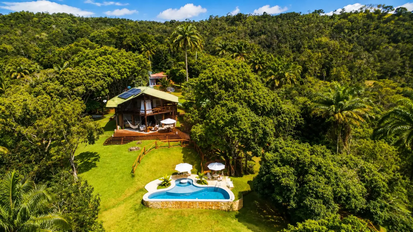 Vista aérea de casa na mata com gramado e área de lazer