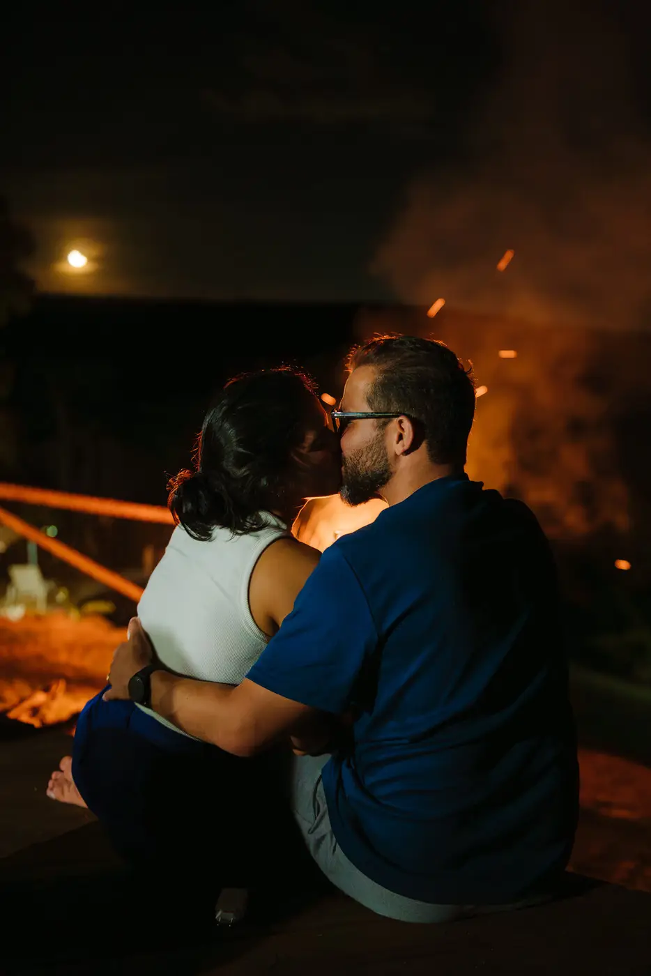 Casal ao redor da fogueira, à noite